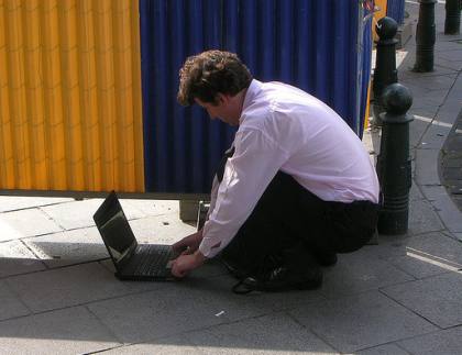 Man on laptop in street: