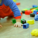 Toddler playing with colourful toys