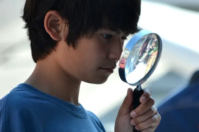 boy holding magnifying glass