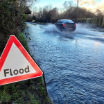 lood sign by the side of a flooded road in the south of England