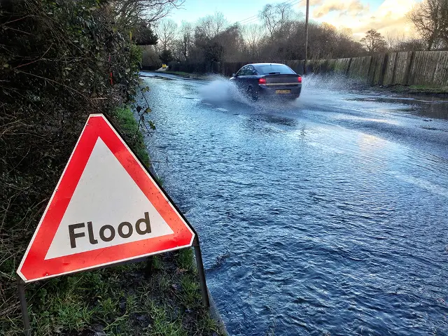 lood sign by the side of a flooded road in the south of England
