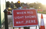 Roadworks sign with red traffic light