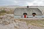 Thatched cottage in sand dunes