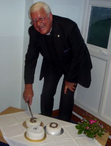 Rev. Mike Exell cutting the cake