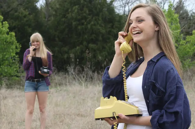 girls on phone in field 