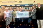 A happy group of Bembridge Community Library committee members and volunteers take delivery of a £2,312.50 cheque from Bembridge Sailing Club. Handing over the cheque on behalf of Bembridge Sailing Club is Fiona Greenwood (fifth from left) and accepting it for Bembridge Community Library is Jonathan Bacon (second right). Sailing Club Commodore Jos Coad is on the far right of the picture.