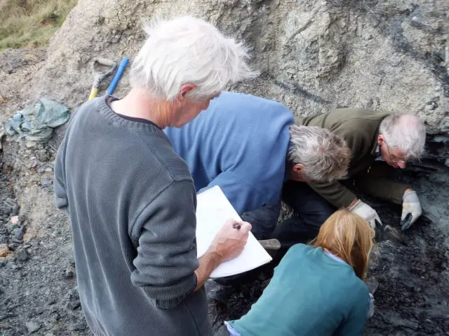 Nick Chase sketching as a dinosaur excavation proceeds