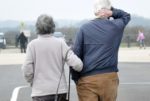 elderly couple walking in car park