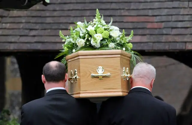 Coffin on the shoulders of funeral directors