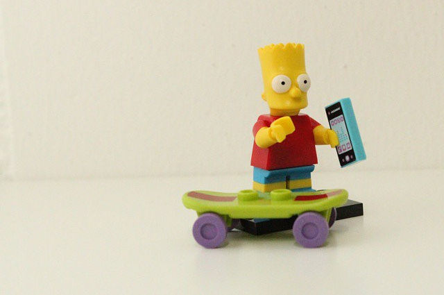 bart simpson on a skateboard with a smartphone