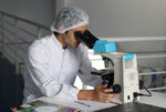 male lab technician looking into microscope