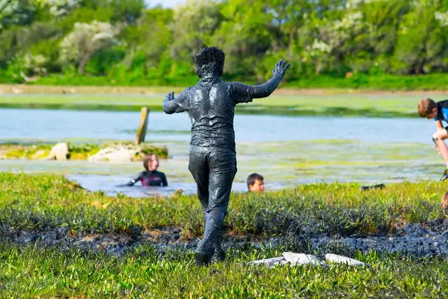 Person covered in mud by Newtown Creek