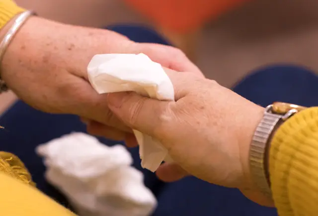 People holding hands with tissue - Mountbatten Bereavement Support