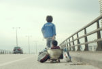 image from the film capernaum showing two kids walking along motorway