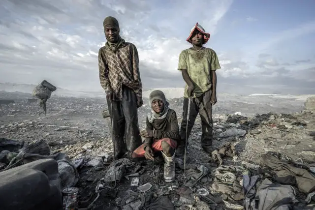 People on waste heap (Haiti Waste in Time Exhibition) © Giles Clark