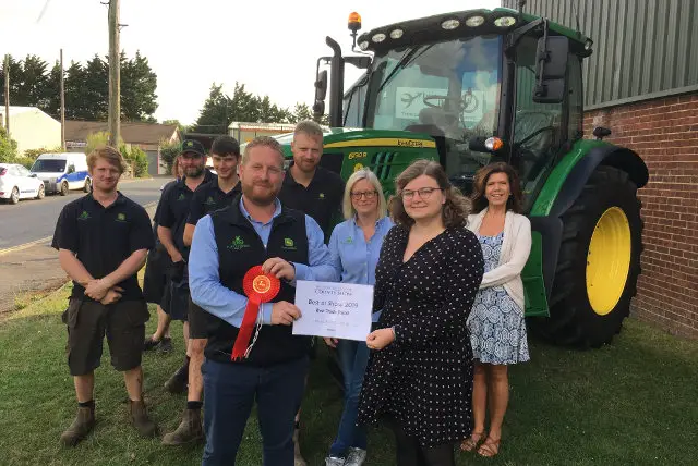 Staff from Hunt Forest Group standing in front of tractor to receive their award