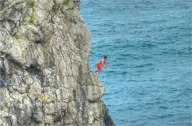 man jumping from cliff
