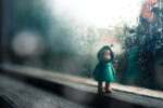 toy figure standing in the window with rain outside