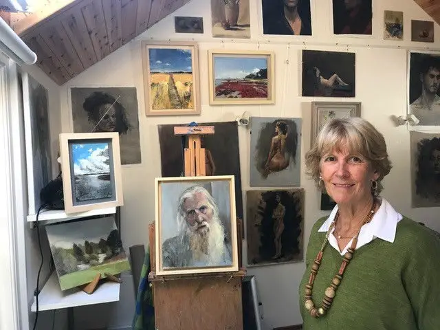 Clare Alexander standing in front of her paintings