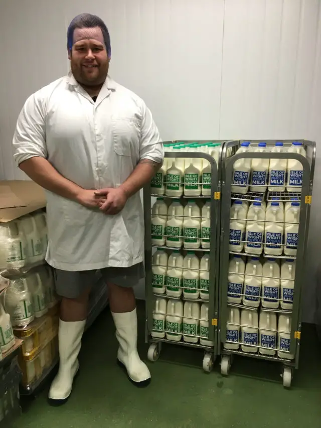 Staff member at Isle of Wight Milk processing plant at Briddlesford Dairy Farm with finished milk product