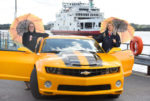 bumble bee car with two women and red funnel fery in background