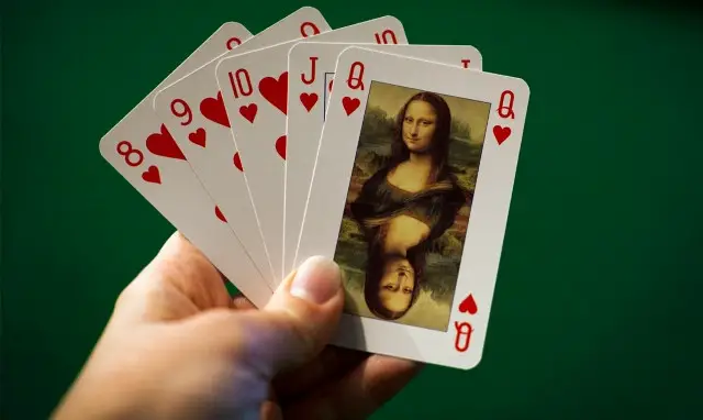 hand of playing cards with queen of hearts on top