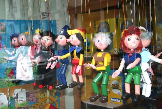 puppets on a string in a shop window