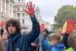 Extinction Rebellion protesters holding up red hands
