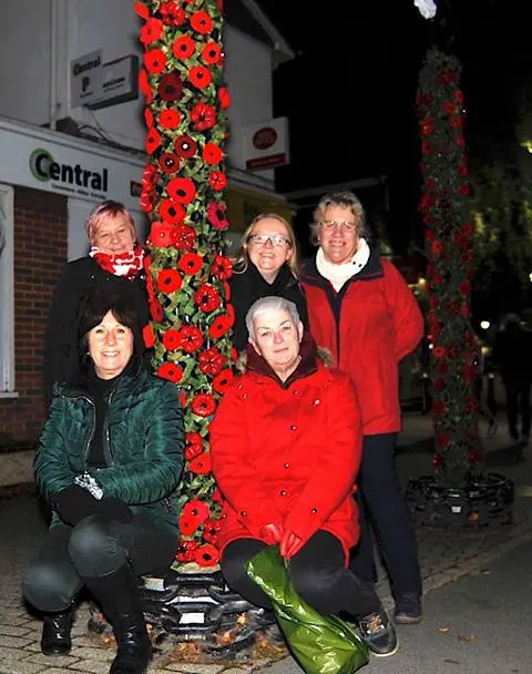 East Cowes WI members by the Town Arch covered with knitted poppies