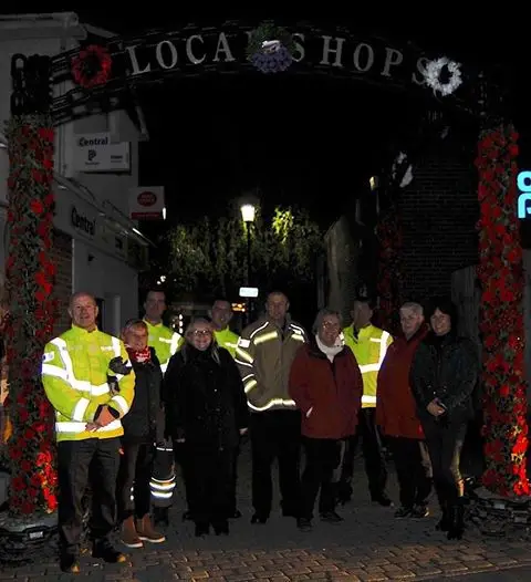 Members of the community by the decorated Town Arch