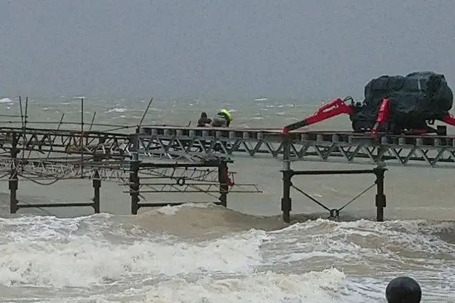 Men working on Totland Pier in the storm