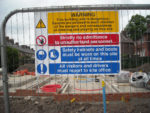 fence of building site with warning signs