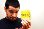 Man holding up card with 'oops' written on it