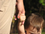 adult holding a child's hand