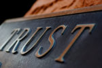 the word trust engraved on a sign