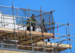 Men standing on scaffolding around a building