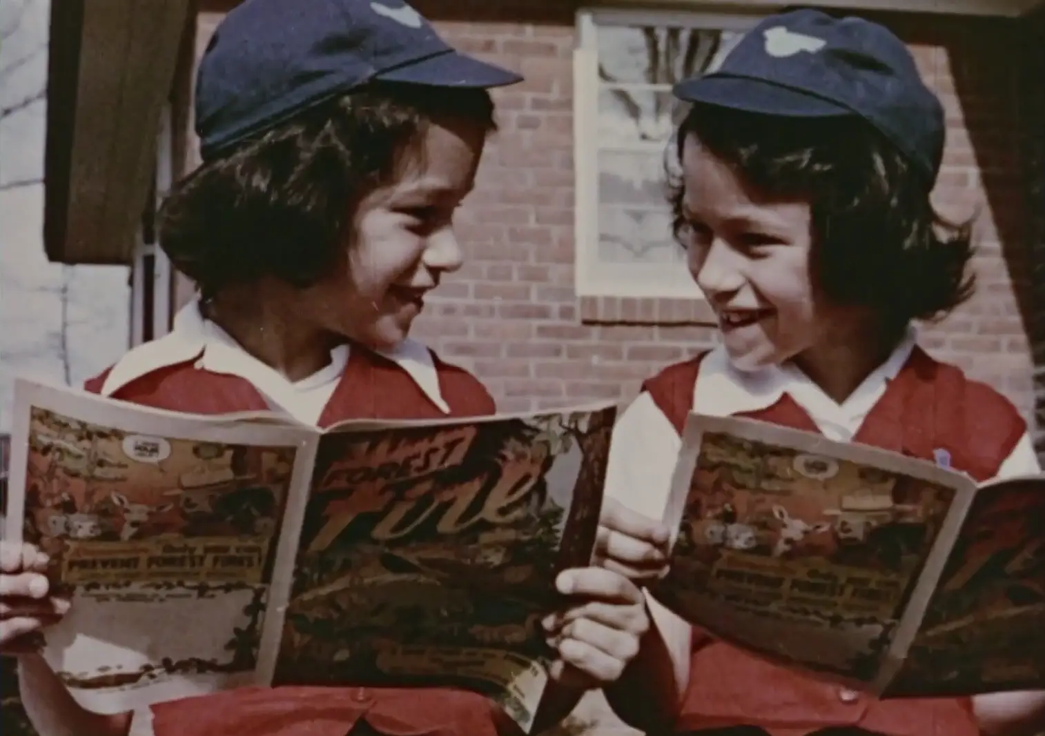 Screen grab from Shadow on the Sea video - two children reading comics