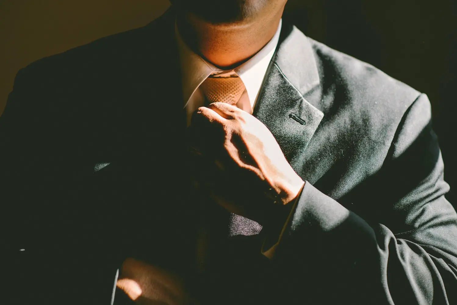 man in a suit tightening his tie
