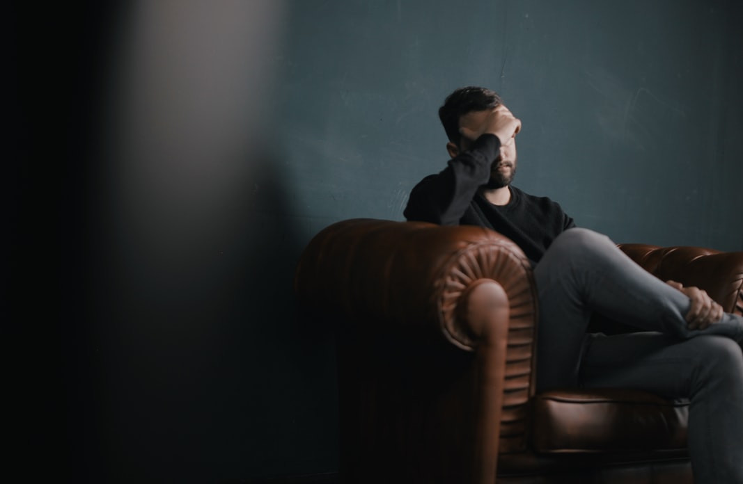 man looking confused sitting on a sofa