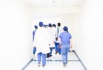surgeons walking away down a hospital corridor