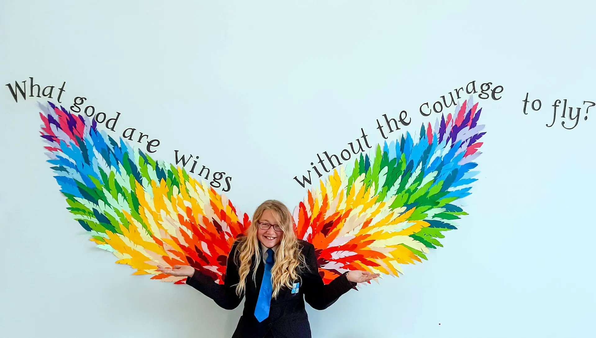 Athiea Mitchell standing against mural of angel wings