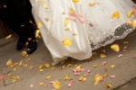 Wedding dress and groom with flower petal confetti