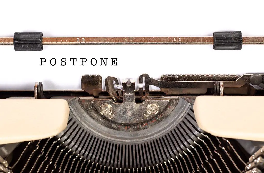 Typewriter with the words Postpone typed on paper