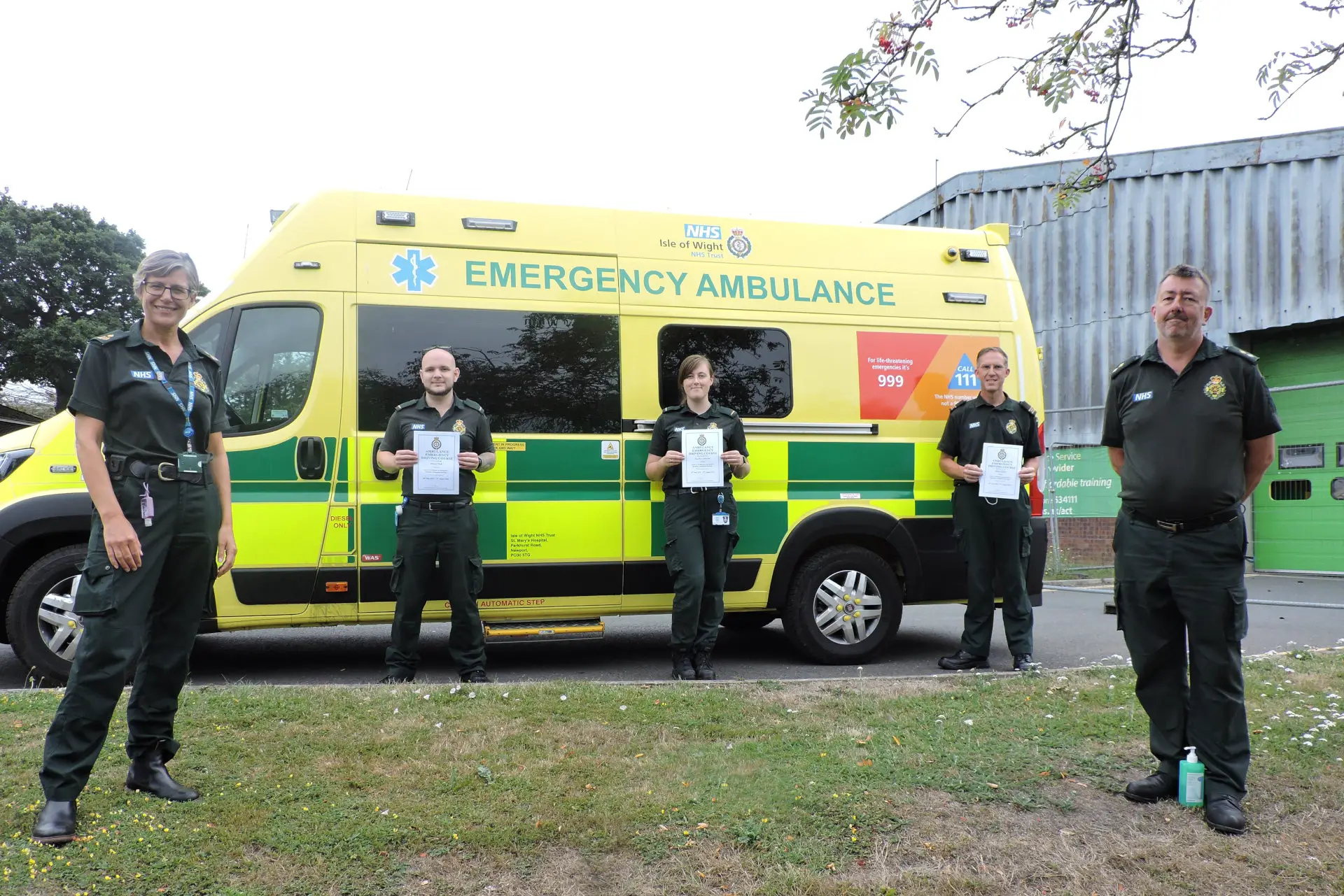 Newly qualified ambulance drivers standing by an ambulance