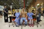 campaign for organ donation - three people sitting in train terminal in gowns with drips