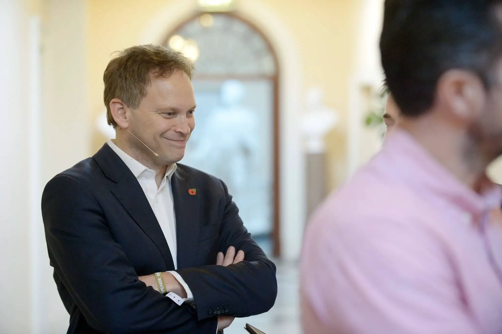 grant shapps standing with his arms crossed