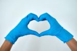 hands with blue latex gloves shaped into a heart