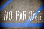 no parking sign painted on road with blue cross hatching