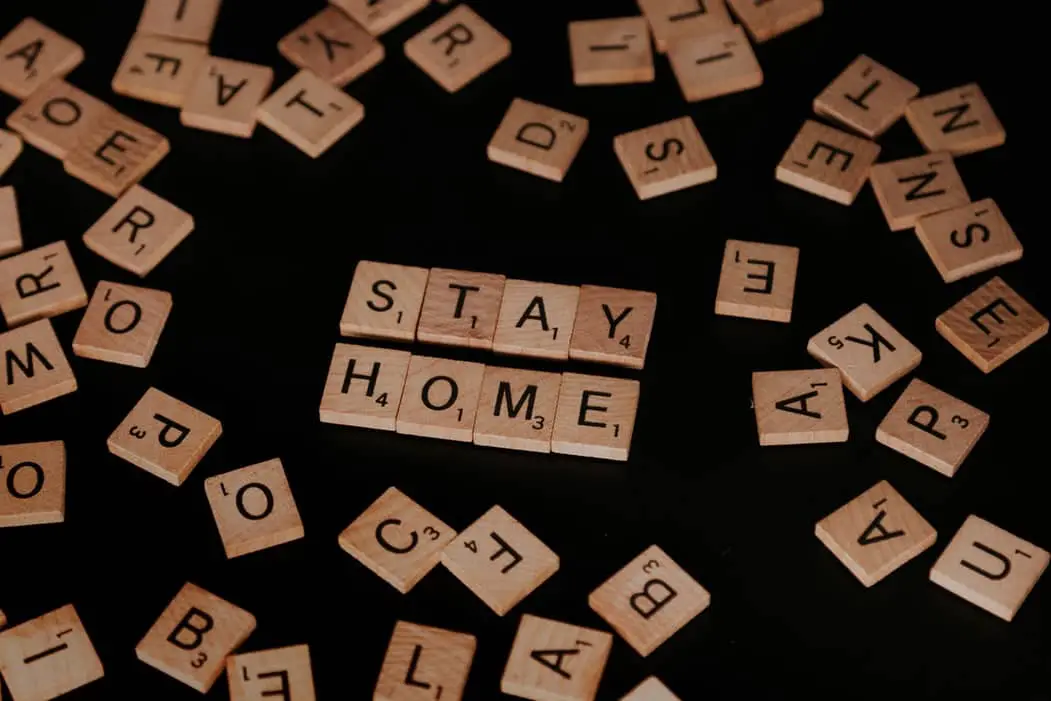 scrabble letters on the table spelling Stay Home