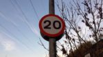 20mph road sign with blue sky and white clouds in background